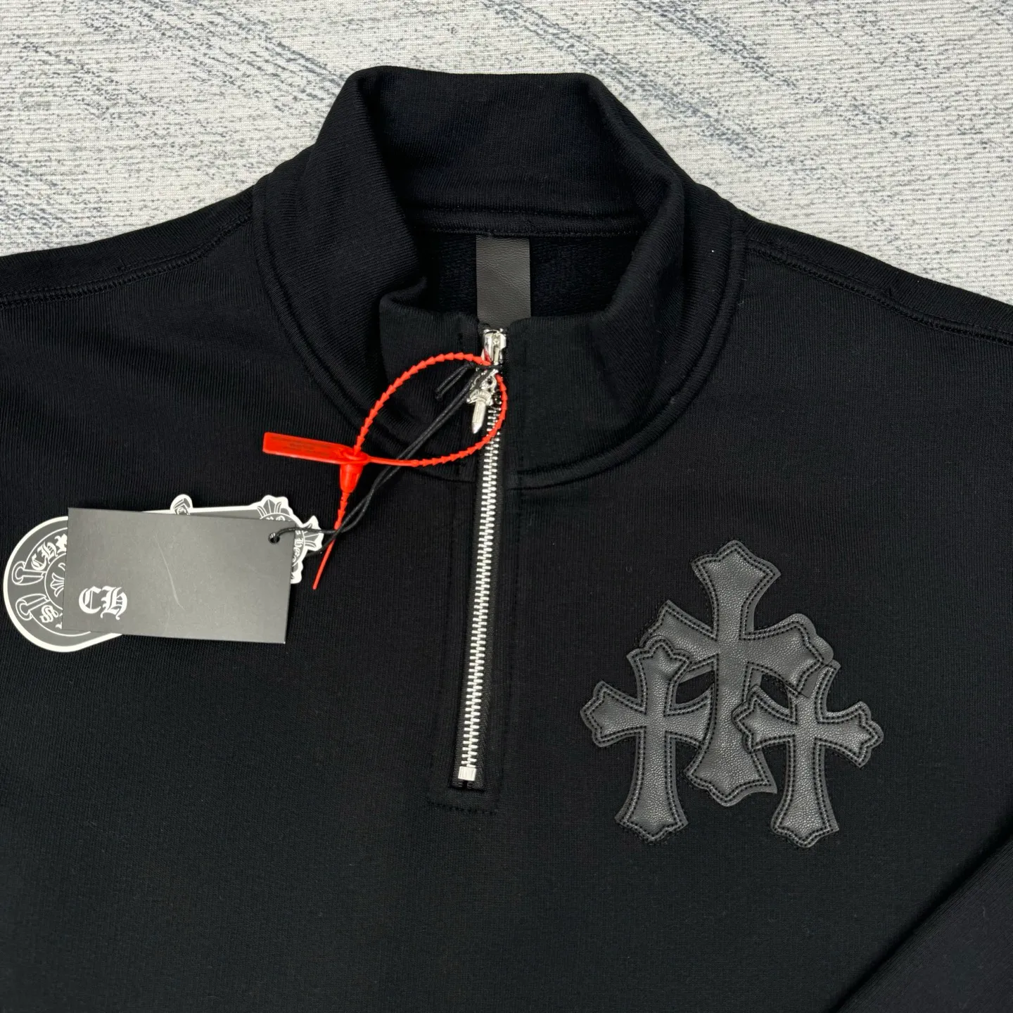 P406 Chrome Heart FW25 leather cross half-zip sweatshirt Size: S/M/L/XL Made of high-weight pure cotton terry fabric Pre-shrunk to ensure wearing stability Three-dimensional leather cross label Half-zip neckline with dagger-shaped zipper pull Combined with curved hem tailoring and kangaroo pocket